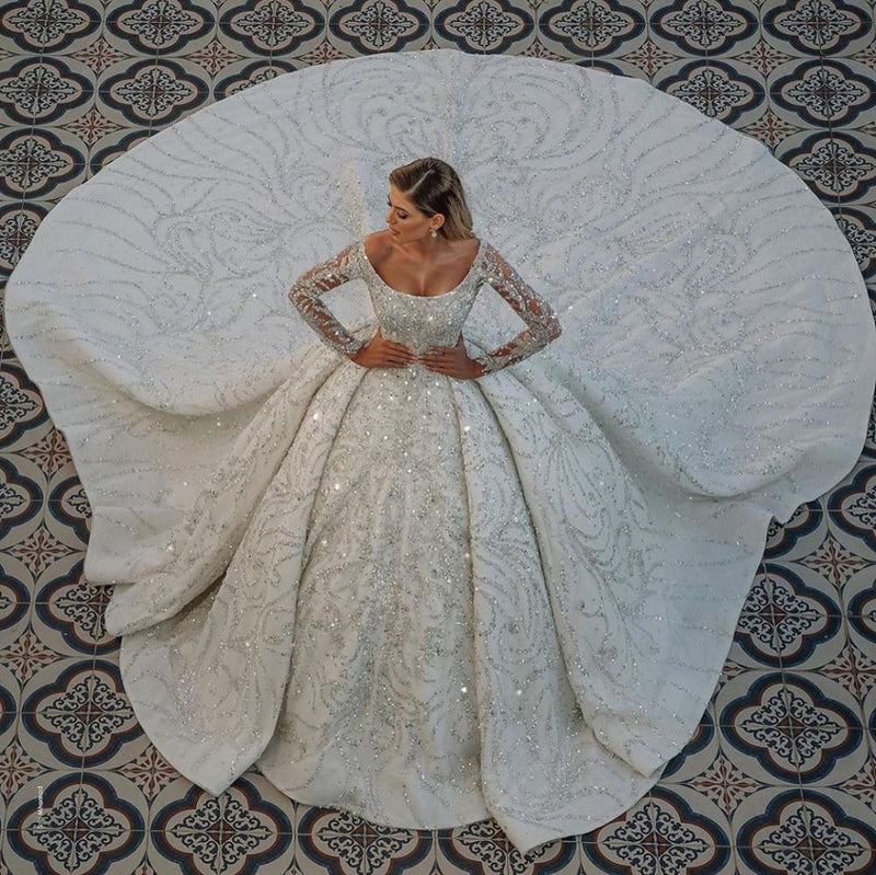 Looking for a dress in Satin, A-line style, and AmazingBeading,Sequined work? We meet all your need with this Classic Luxurious Princess Ball Gown Long Sleevess Sparkly sequins Bridal Gowns with Sweep Train.