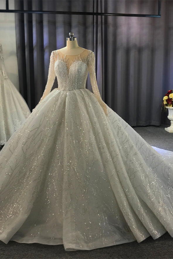 Wanna get a dress in Tulle, Ball Gown style, and delicate Beading,Appliques,Ruffless work? We meet all your need with this Classic Shiny Ball Gown Tulle Jewel Long Sleevess Ruffless Wedding Dress at factory price.